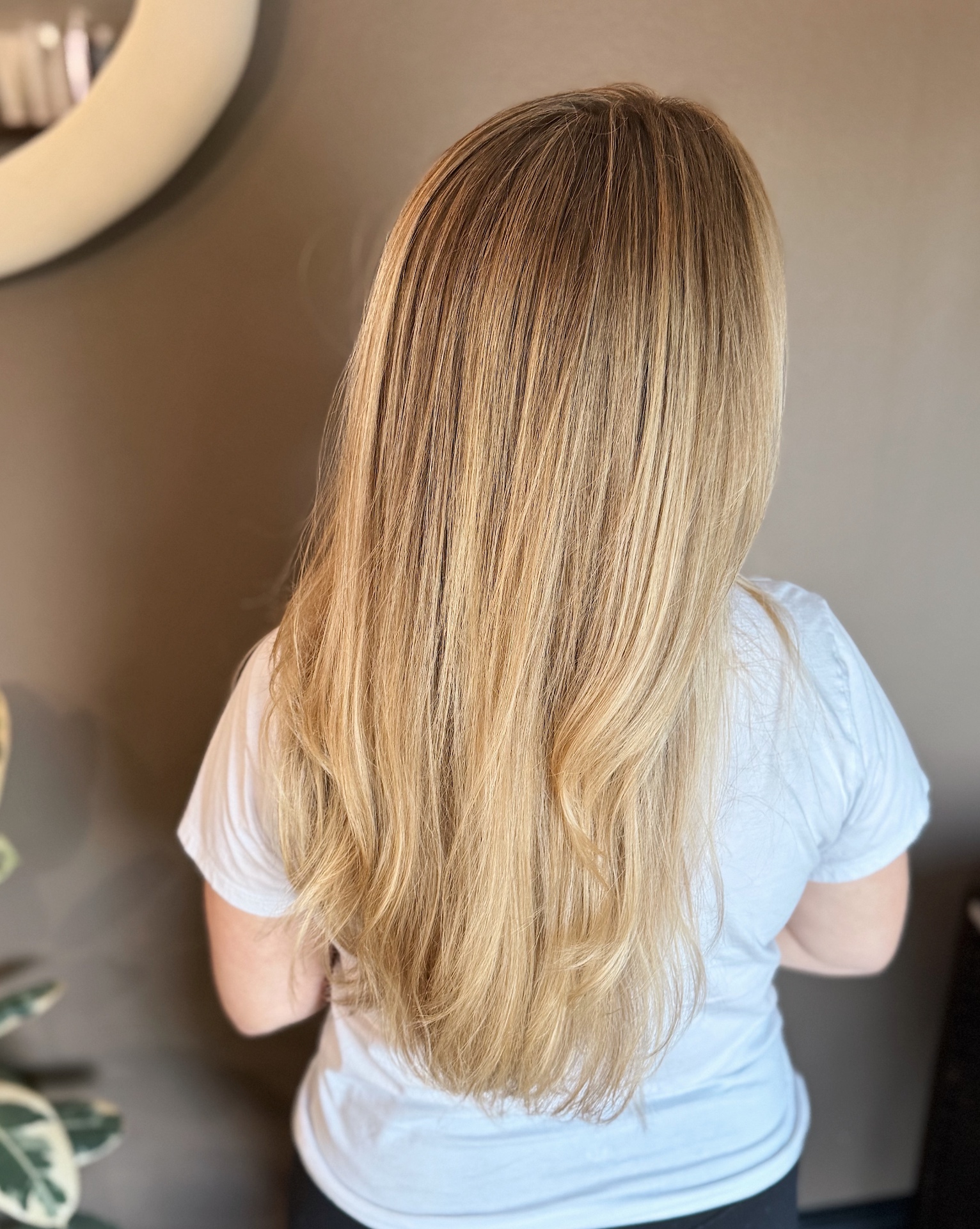 Back view of long blonde hair with natural dimensional highlights and seamless root melt styled straight by Jenna Schermerhorn in Glen Allen, VA